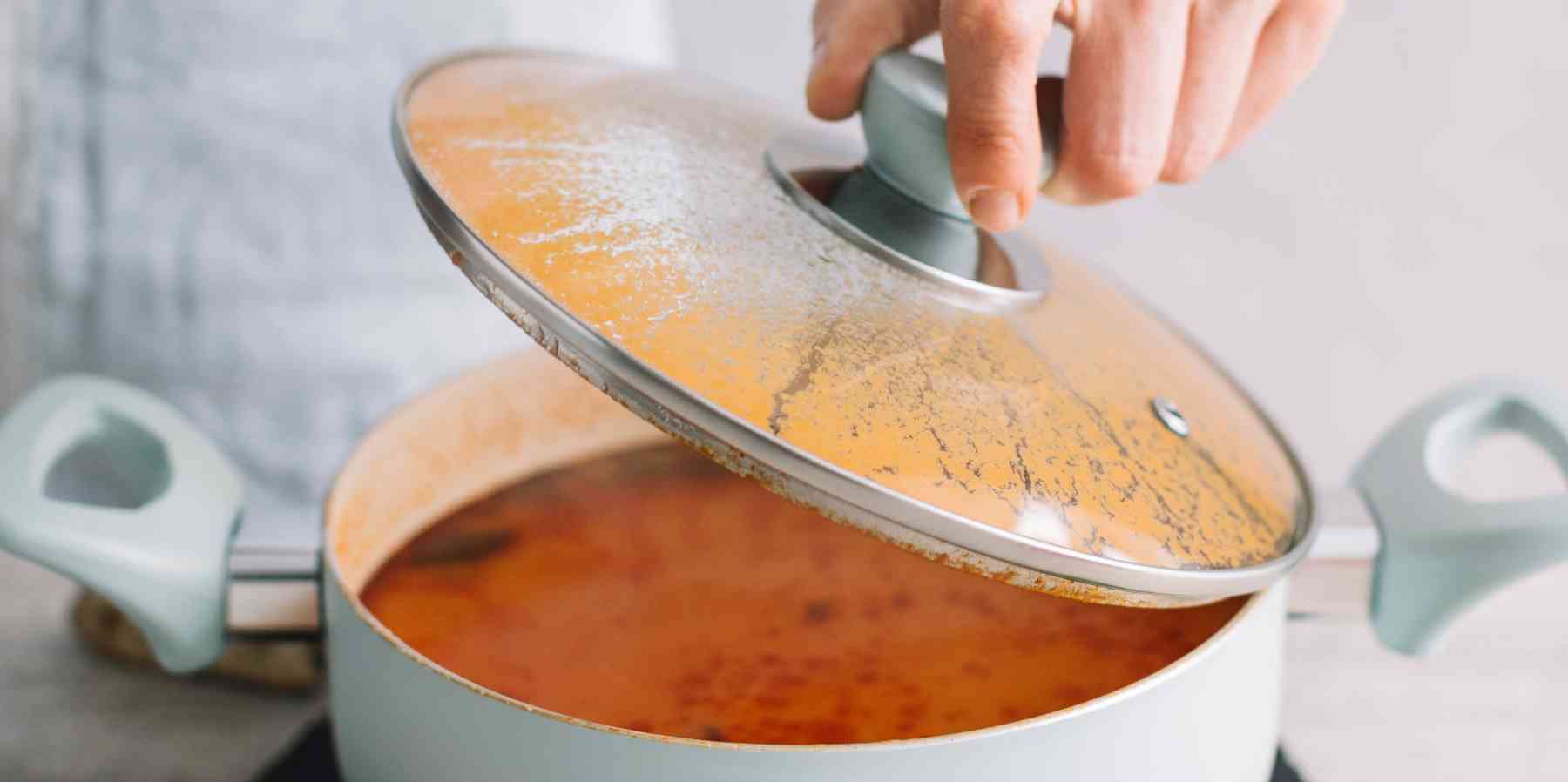 Coperchio di una pentola sporco da sugo di pomodoro