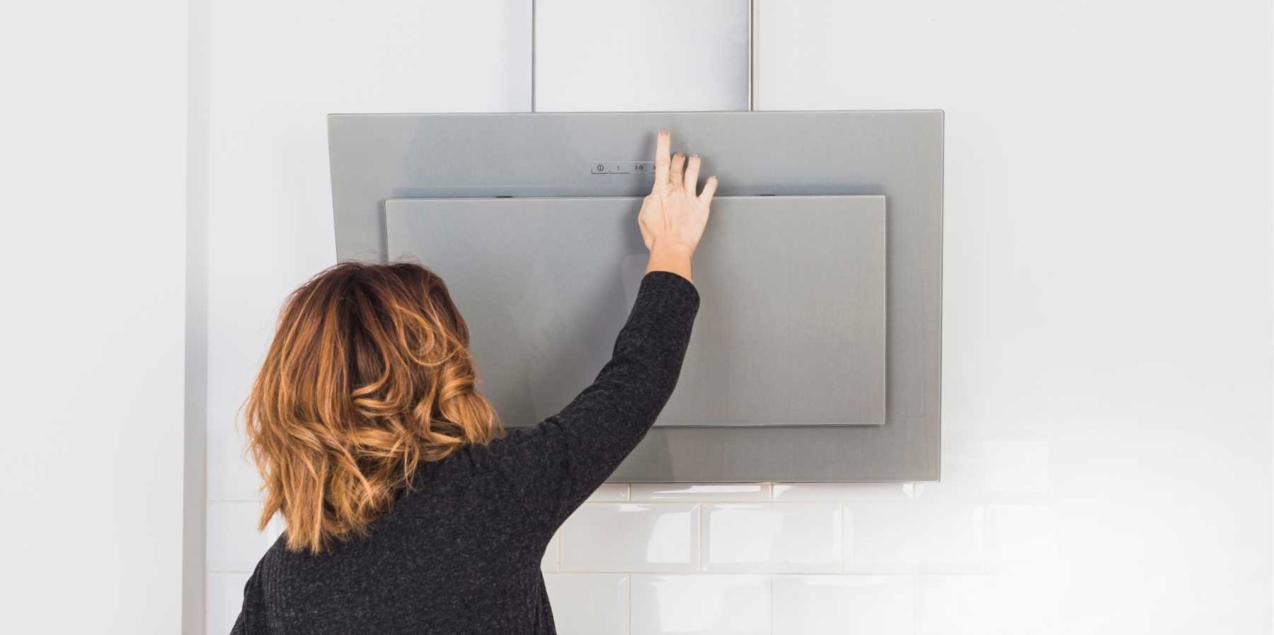 Donna che spegne la cappa prima di controllarla